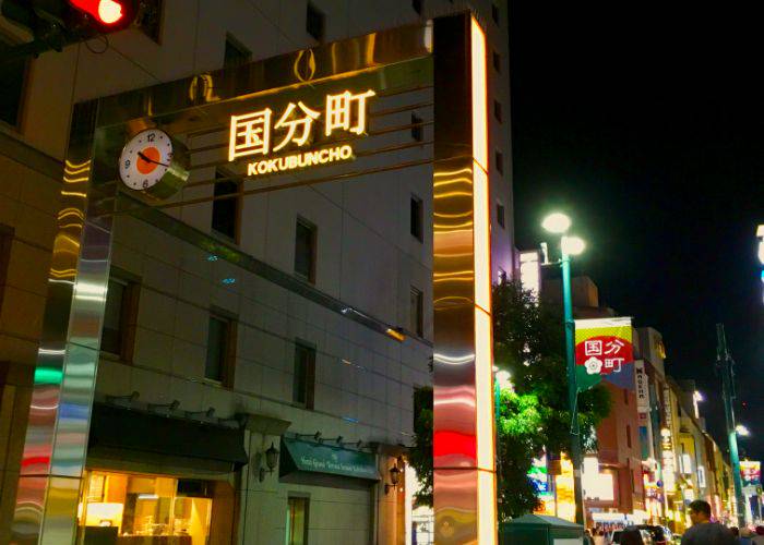 The entrance to Kokubuncho, Sendai, at night. The bars light up the night.